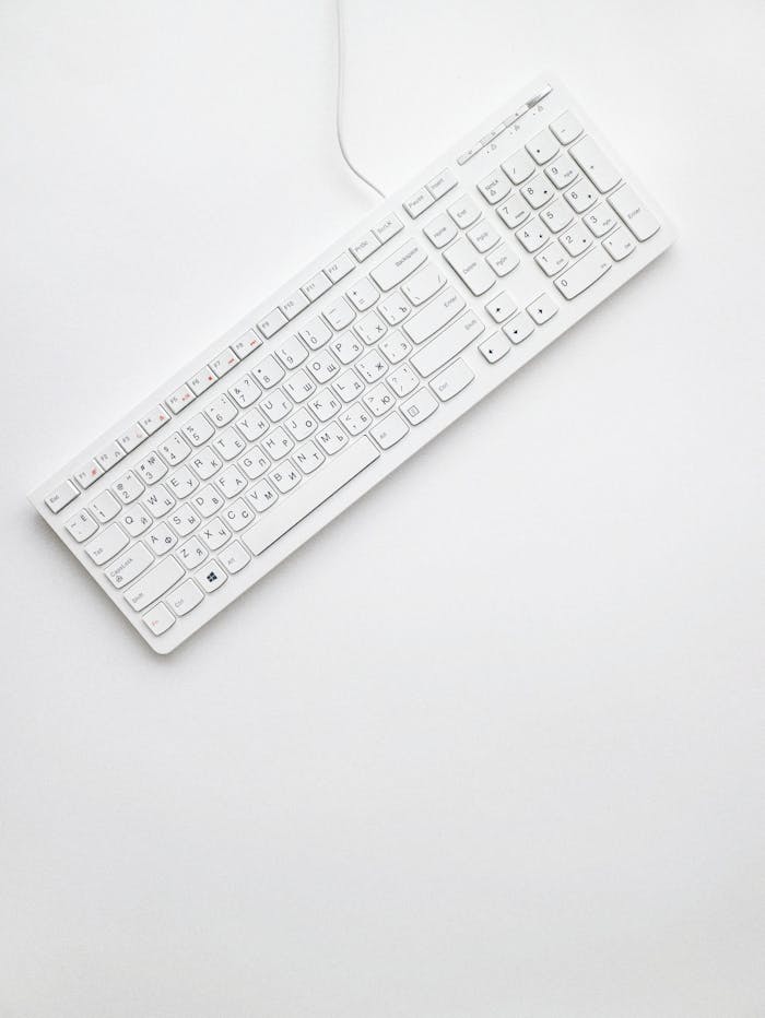 A modern white keyboard on a white background showcasing minimalist design and clean aesthetics.